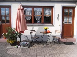 a table and chairs and an umbrella in front of a building at Ferienwohnung Luzia in Eichstegen