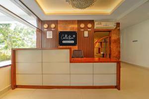 a waiting room with a counter and a mirror at Super Collection O RTO Office Uzhavoor Formerly Hotel Zodiac in Puduveli