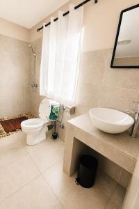 a bathroom with a toilet and a sink at Soleya in Antananarivo