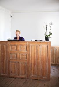 a woman standing in front of a wooden table at Hotel Hellstens Malmgård in Stockholm