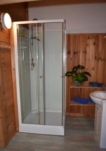 a shower with a glass door in a bathroom at Trésor en Bois Chambres d'Hôtes in Autoire
