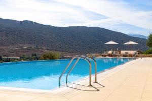Ein Swimmingpool mit Bergen im Hintergrund in der Unterkunft Crete Golf Club Hotel in Hersonissos