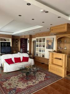 a living room with a white couch and red pillows at Balatonalmádi Pipacs Villa in Balatonalmádi
