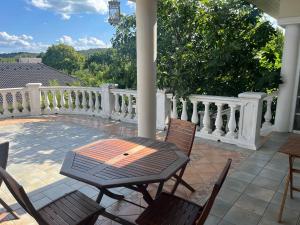 a patio with a table and chairs on a porch at Balatonalmádi Pipacs Villa in Balatonalmádi