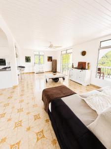 a large white room with two beds and a table at La Mansarde in Le Robert