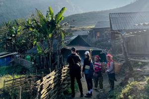 a group of people walking down a dirt road at The Happy Cozy Corner! in Lao Cai