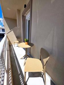 a balcony with two chairs and a table and a window at Anthouli homes 4, steps from beach and centre in Kardamaina