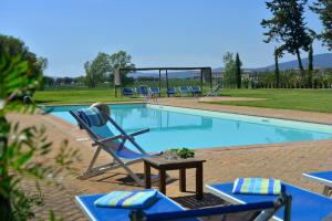 a pool with chairs and a table next to it at Apartment I Fontanili in Pescia Romana