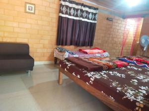 a room with two beds and a couch in it at Lovelynest homestay in Attigundi