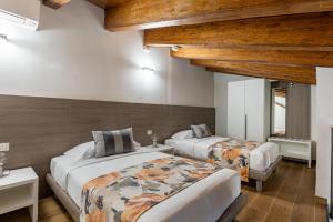 two beds in a room with wooden ceilings at Agriturismo Santa Rosa in Lubriano +97 photos