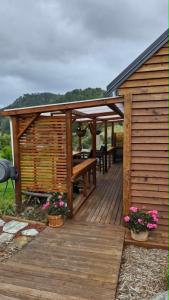 a wooden deck with a pergola and a table at Kōtare Cabin, Thames Coast in Tapu