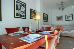 a dining room with a wooden table with chairs at SpainKarmaSun in Torrox Costa