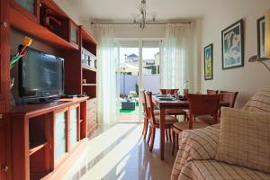 a living room with a television and a table with chairs at SpainKarmaSun in Torrox Costa