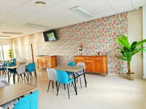 a waiting room with tables and chairs and a plant at Camping El Burgo Bungalows in Orellana la Vieja