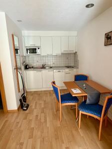 a kitchen with a table and chairs in a room at Apart Jil-Marie Studio 7 in Samnaun