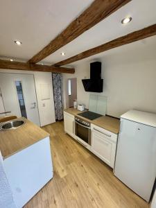 a kitchen with white cabinets and a white refrigerator at Ferienscheune Rheingoldhof in Sankt Goar +8 photos