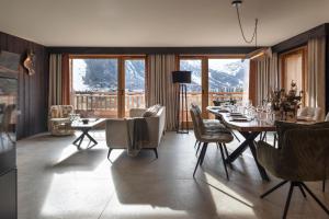 a dining room with a table and chairs and mountains at Chalet Skadi - Village Montana in Val-d'Isère