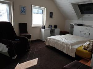 a bedroom with a bed and a chair and a window at Ferienwohnung Irene in Bad Saulgau
