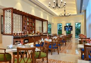 a restaurant with tables and chairs and a bar at Fortune Miramar, Goa - Member ITC's Hotel Group in Panaji