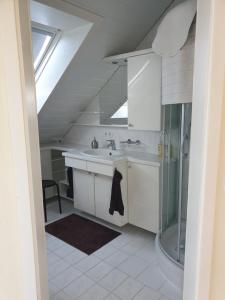 a white bathroom with a sink and a shower at Ferienwohnung Irene in Bad Saulgau +19 photos