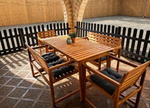 a wooden table with two chairs and a table with a plant on it at Finca Sueño Crea in Lorca