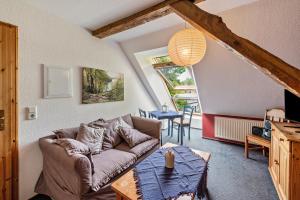 a living room with a couch and a table at Dachstudio Seeblick in Krüselin