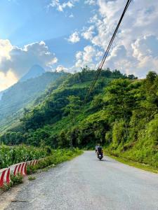 a person riding a motorcycle down a mountain road at The Happy Cozy Corner! in Lao Cai +68 photos