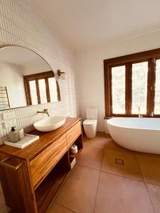 a bathroom with two sinks and a tub and a toilet at Hoop Lodge in Bellingen +26 photos