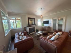 a living room with two couches and a fireplace at Hoop Lodge in Bellingen