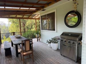 a patio with a table and a grill on a house at Hoop Lodge in Bellingen