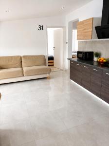 a living room with a couch and a tile floor at Powidz Work & Stay in Powidz +6 photos