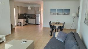 ein Wohnzimmer und eine Küche mit Sofa und Tisch in der Unterkunft Horizon Corner in Ladochórion