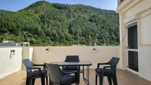 Ein Tisch und Stühle auf einem Balkon mit Bergblick in der Unterkunft Horizon Corner in Ladochórion