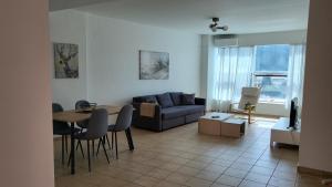 ein Wohnzimmer mit Sofa, Tisch und Stühlen in der Unterkunft Horizon Corner in Ladochórion