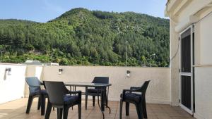 Ein Tisch und Stühle auf einem Balkon mit Bergblick in der Unterkunft Horizon Corner in Ladochórion