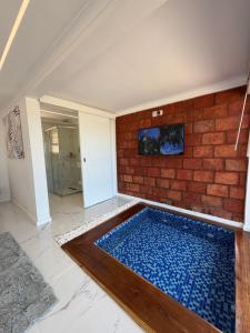 a swimming pool in a room with a brick wall at Koko Beach - Honeymoon Suite in Vila Praia Do Bilene