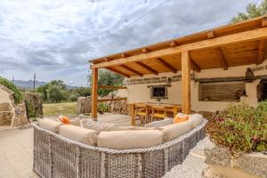 a patio with couches and a table and a fireplace at Villa NiLo Natura - Rustic Mountain Charm in Telti