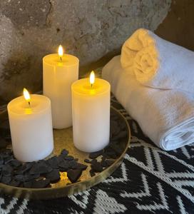 three candles sitting on a tray with a towel at Piedra y Luz in Buendía