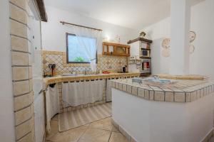 a kitchen with a sink and a counter top at Villa NiLo Natura - Rustic Mountain Charm in Telti +24 photos