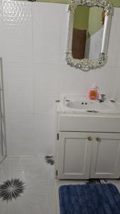 a bathroom with a white sink and a mirror at Smithy's Apartment 2 in Ribishi