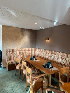 a restaurant with a wooden table and chairs and a bench at Waldhaus am See in Willingen