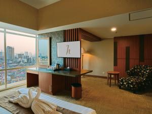 a hotel room with a bed and a desk and a chair at Horison Ultima Menteng Jakarta in Jakarta
