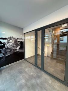 a room with glass doors and a painting on the wall at Apartament Bursztynowy Lębork in Lębork