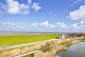 a road next to a river next to a field at Meerblick 60 in Nordstrand