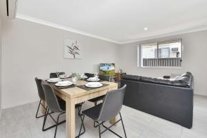 a dining room with a table and chairs and a couch at Hunter Hideaway in Cessnock