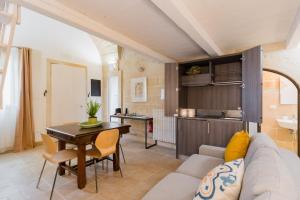 a living room with a couch and a table and a kitchen at Corte Dei Saraceni - Lecce Selection in Lecce