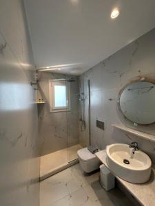 ein Badezimmer mit Waschbecken, Toilette und Spiegel in der Unterkunft Hotel Zannet in Parikia