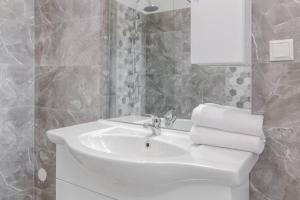 a white bathroom with a sink and a mirror at Azure Wave - Ultra Central in Oradea +16 photos