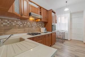a kitchen with wooden cabinets and a counter top at Azure Wave - Ultra Central in Oradea