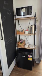 a kitchen with a blackboard and a microwave on a shelf at Sunshine cottage in Clontarf